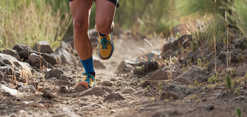 Trail running man on mountain path exercising