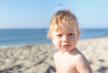 portrait boy on the beach. eight month old blond boy