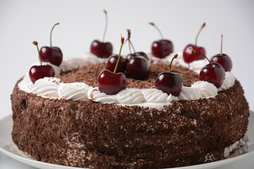Black forest cake, Schwarzwald pie, dark chocolate and cherry dessert on a white background. Black forest cake decorated with whipped cream and cherries.