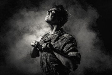 Black white portrait of a young soldier in combat coloring, scars and bruises, holding a machete on...