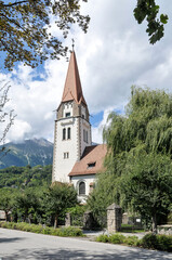 Fototapeta na wymiar Jardines e iglesia de Cristo en un barrio residencial a las afueras de la ciudad de Innsbruck, Austria