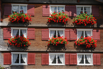 Fachada con ventanas y flores de una casa rural en la región de Vorarlberg, Austria