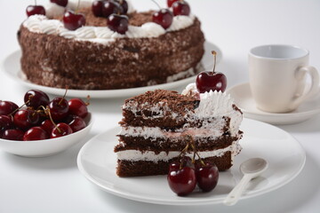 Black forest cake, Schwarzwald pie, dark chocolate and cherry dessert on a white background. Black forest cake decorated with whipped cream and cherries.