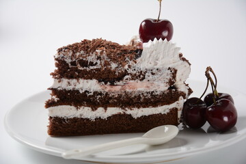 Black forest cake, Schwarzwald pie, dark chocolate and cherry dessert on a white background. Black forest cake decorated with whipped cream and cherries.