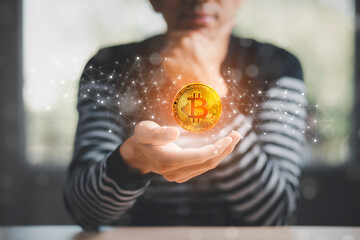 Man hand hold a bitcoin as part of a business network on room background. bitcoin cryptocurrency ideas concept and virtual financial chart diagram, Digital symbol of a new virtual currency