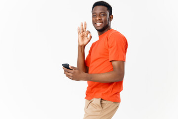 happy guy of african appearance gesturing with his hands and holding a mobile phone 