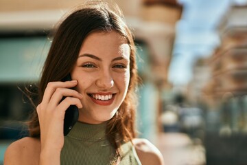 Young caucasian girl smiling happy talking on the smartphone at the city.