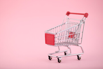 Shopping cart on pink background