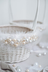 White basket with feathers, pearl and jewelry