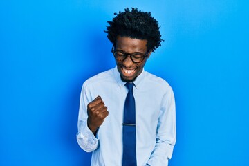 Fototapeta na wymiar Young african american man wearing business clothes celebrating surprised and amazed for success with arms raised and eyes closed