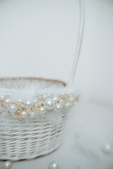 White basket with feathers, pearl and jewelry