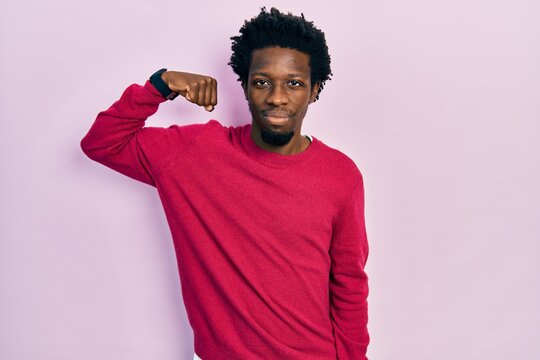 Young african american man wearing casual clothes strong person showing arm muscle, confident and proud of power