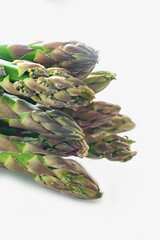 Fresh green shoots of asparagus isolated on white background.