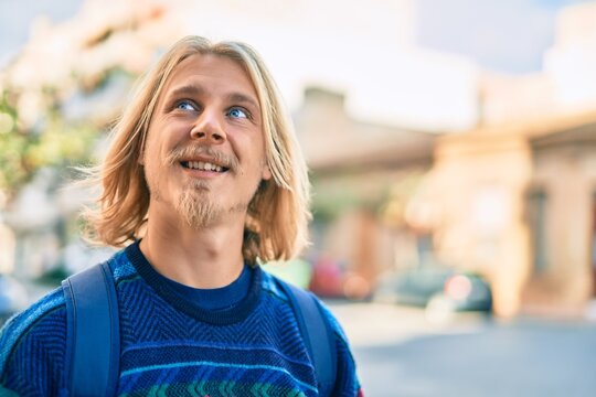 Young scandinavian student man smiling happy standing at the city.
