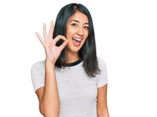 Obraz na płótnie Canvas Beautiful asian young woman wearing casual white t shirt smiling positive doing ok sign with hand and fingers. successful expression.