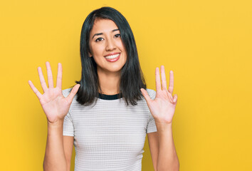 Beautiful asian young woman wearing casual white t shirt showing and pointing up with fingers number nine while smiling confident and happy.