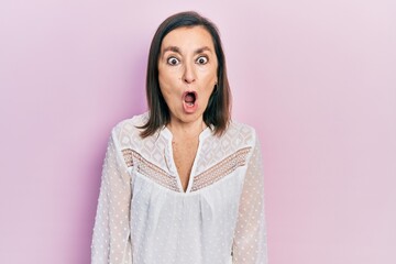 Fototapeta premium Middle age hispanic woman wearing casual clothes afraid and shocked with surprise expression, fear and excited face.