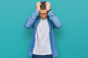 Young caucasian man wearing casual clothes suffering from headache desperate and stressed because pain and migraine. hands on head.