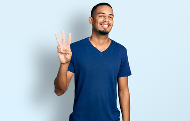 Young african american man wearing casual t shirt showing and pointing up with fingers number three...