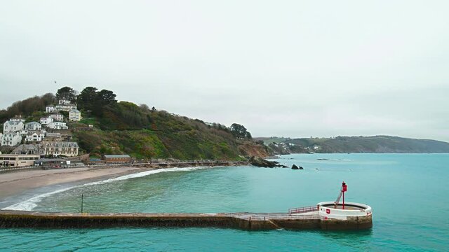 Looe Beach - South East Cornwall in 4K. Looe - coastal town and civil parish in England with multiple old English houses on the cliff and seashore of Looe Bay in the English Channel.