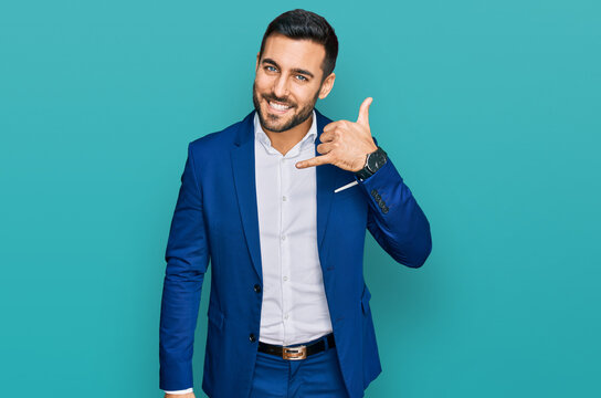 Young Hispanic Man Wearing Business Jacket Smiling Doing Phone Gesture With Hand And Fingers Like Talking On The Telephone. Communicating Concepts.