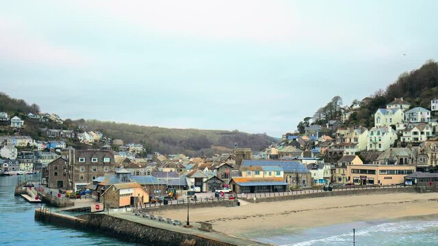 Looe Beach - South East Cornwall in 4K. Looe - coastal town and civil parish in England with multiple old English houses on the cliff and seashore of Looe Bay in the English Channel.
