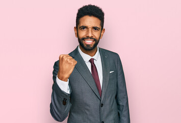 Young african american man wearing business clothes angry and mad raising fist frustrated and furious while shouting with anger. rage and aggressive concept.