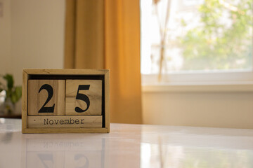 Wooden blocks of the calendar represents the date 25 and the month of November on the background of...