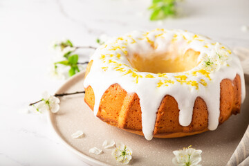 Homemade lemon cake decorated with white glaze and zest