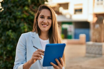 Obraz premium Young blonde businesswoman working using touchpad at the city.