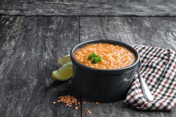 Vegan Red Lentil Soup in clay pot on rustic table