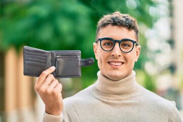 Young hispanic man smiling happy standing at the city.
