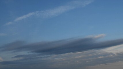 Blue sky with grey spindrift clouds. Nature sky background. Cloudscape with dark cloud before rain