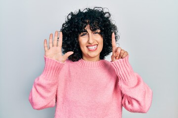 Fototapeta na wymiar Young middle east woman wearing casual clothes showing and pointing up with fingers number six while smiling confident and happy.