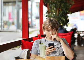Lifestyle portrait of a young man using a smart phone outdoors