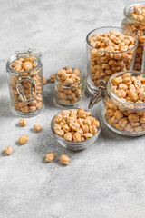 Uncooked dried chickpeas in a different glass jars and bowls.