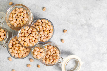Uncooked dried chickpeas in a different glass jars and bowls.