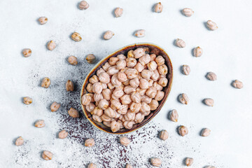 Uncooked dried chickpeas in a different glass jars and bowls.