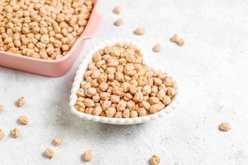 Uncooked dried chickpeas in a different glass jars and bowls.