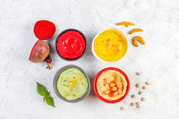 Traditional Middle eastern food various hummus. Green,yellow,beet and traditional hummus in small bowls.