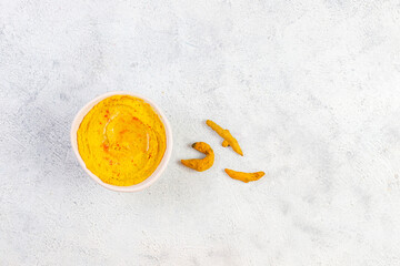 Obraz na płótnie Canvas Homemade organic yellow turmeric hummus in bowl.