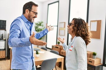 Fototapeta premium Two middle age business workers smiling happy and talking at the office.