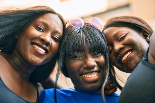 Three African American Friends Smiling Happy Hugging At The City.