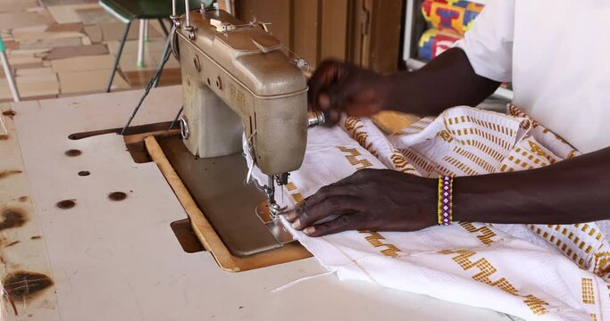  Sewing hand loom Kente strips cloth fabric Kumasi Ghana. Kente is worn by the king of the Ashanti Kingdom. Complex handwoven silk or cotton takes days to make.