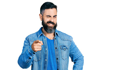 Hispanic man with beard pointing with finger to camera winking looking at the camera with sexy...
