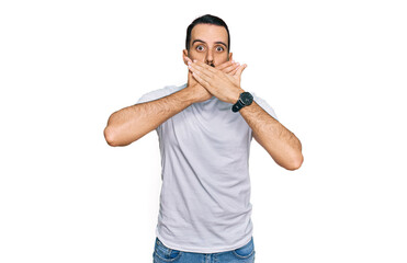 Naklejka premium Young man with beard wearing casual white t shirt shocked covering mouth with hands for mistake. secret concept.