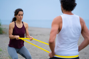 couple of athletes exercising on the beach 