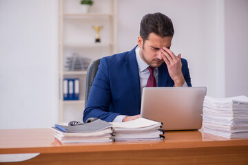 Young businessman and too much work in the office