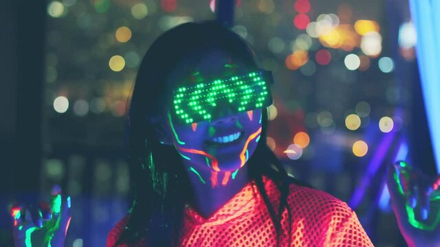 Neon  asian woman dancing. Fashion model woman in neon light, portrait of beautiful model with fluorescent make-up, Art and future design of female disco dancer posing in UV, colorful make up.
