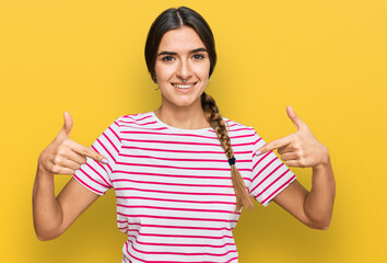 Young hispanic woman wearing casual clothes looking confident with smile on face, pointing oneself...